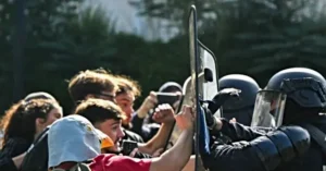A confrontation between protesters and police officers is captured in this news photo, highlighting the tension and conflict during a demonstration.