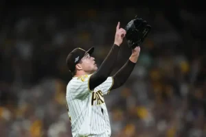 A baseball player in a Pittsburgh Pirates uniform reaches up to catch a ball during a game.