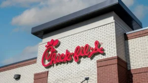 The image shows the exterior of a Chick-fil-A restaurant with its iconic logo prominently displayed on the building.