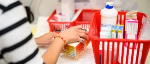 A healthcare worker is organizing medication in a pharmacy setting.