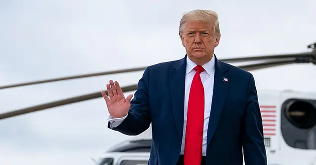 The image shows a person in a suit and red tie waving, with a helicopter in the background.