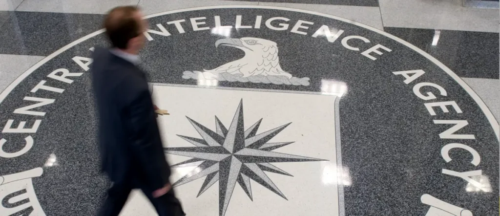 A man walks past the logo of the Central Intelligence Agency on the floor of its headquarters.