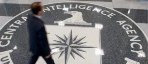 A man walks past the logo of the Central Intelligence Agency on the floor of its headquarters.