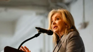 A woman is giving a speech at a podium with a microphone.