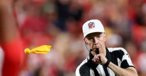 An NFL referee blows his whistle during a game.