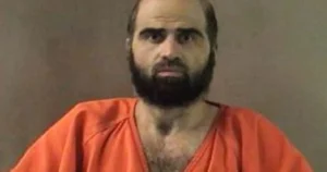 The image shows a person wearing an orange prison uniform, commonly associated with inmates in correctional facilities.