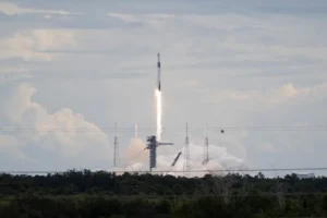 A rocket lifts off from a launchpad, leaving a trail of smoke and fire as it ascends into the sky.