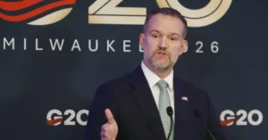 A man in a suit and tie is giving a speech at the G20 event in Milwaukee, 2026.