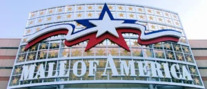 The image shows the iconic sign of the Mall of America, featuring a large star and the text "MALL OF AMERICA" surrounded by stars.