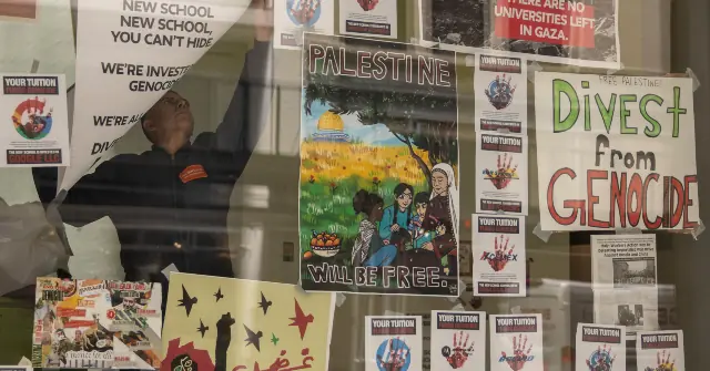The image shows a person raising a poster in front of a wall covered with various protest signs advocating for Palestine and calling for divestment from genocide.