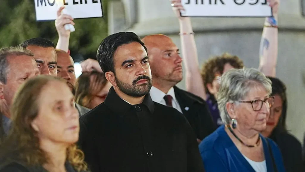 A group of people are gathered in a protest, holding signs and standing together.