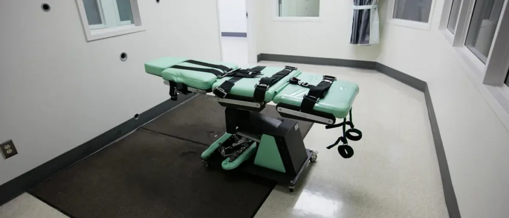 The image shows a restraint chair in a secure room, likely used for medical or forensic procedures.