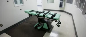 The image shows a restraint chair in a secure room, likely used for medical or forensic procedures.