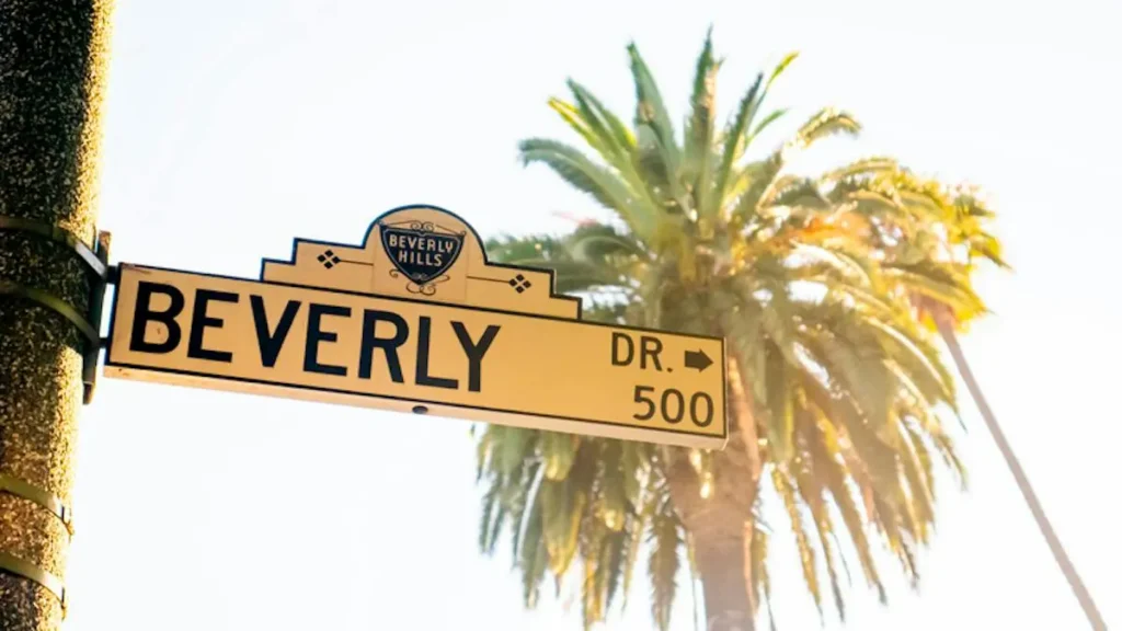 The image shows a street sign for Beverly Drive in Beverly Hills, with a palm tree in the background.