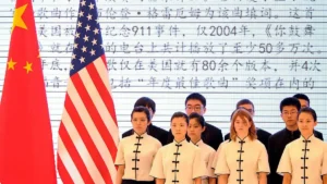 A group of individuals in traditional attire stands in front of the flags of China and the United States, with a backdrop of Chinese text.