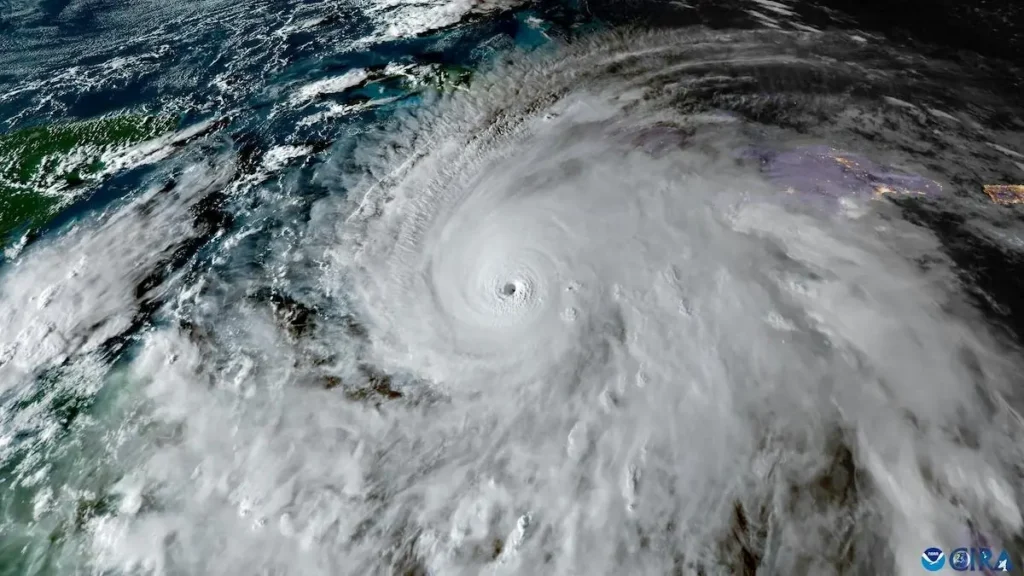 This satellite image shows a powerful hurricane with a well-defined eye and surrounding swirling clouds, indicating intense weather activity.