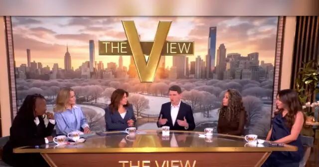 The photo shows a panel of five people sitting at a table on a set with a cityscape background, discussing on the talk show "The View."