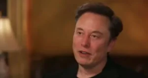 The image shows a person speaking in a casual setting, possibly during an interview or discussion.