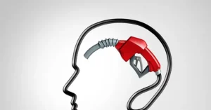 The image depicts a gas pump nozzle inserted into the shape of a human head, symbolizing the concept of fueling or energizing the mind.